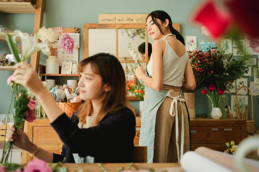 Person expressing creativity through flower arrangement